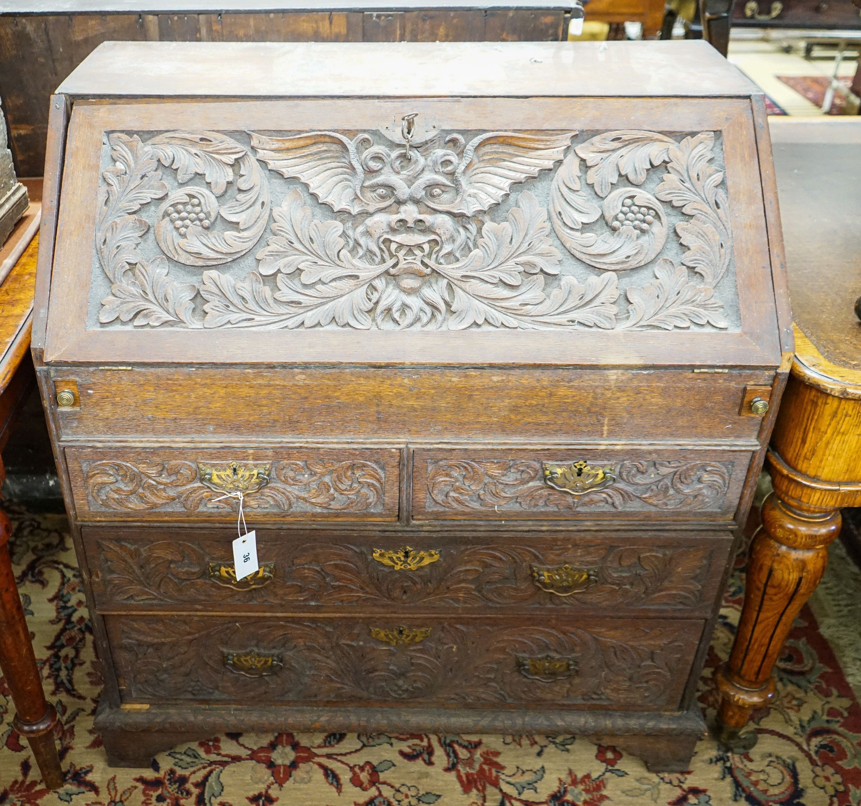 An 18th century later carved oak bureau, width 91cm, depth 53cm, height 101cm